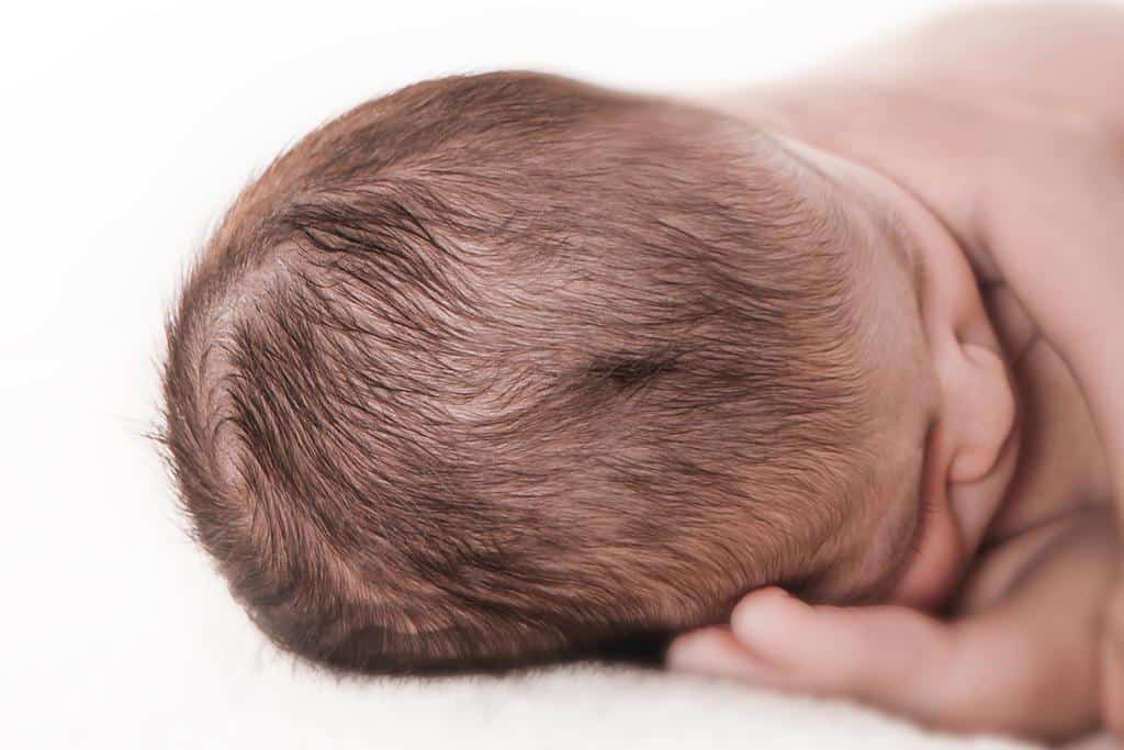primer plano de la coronilla de un recién nacido que duerme en sesión fotográfica