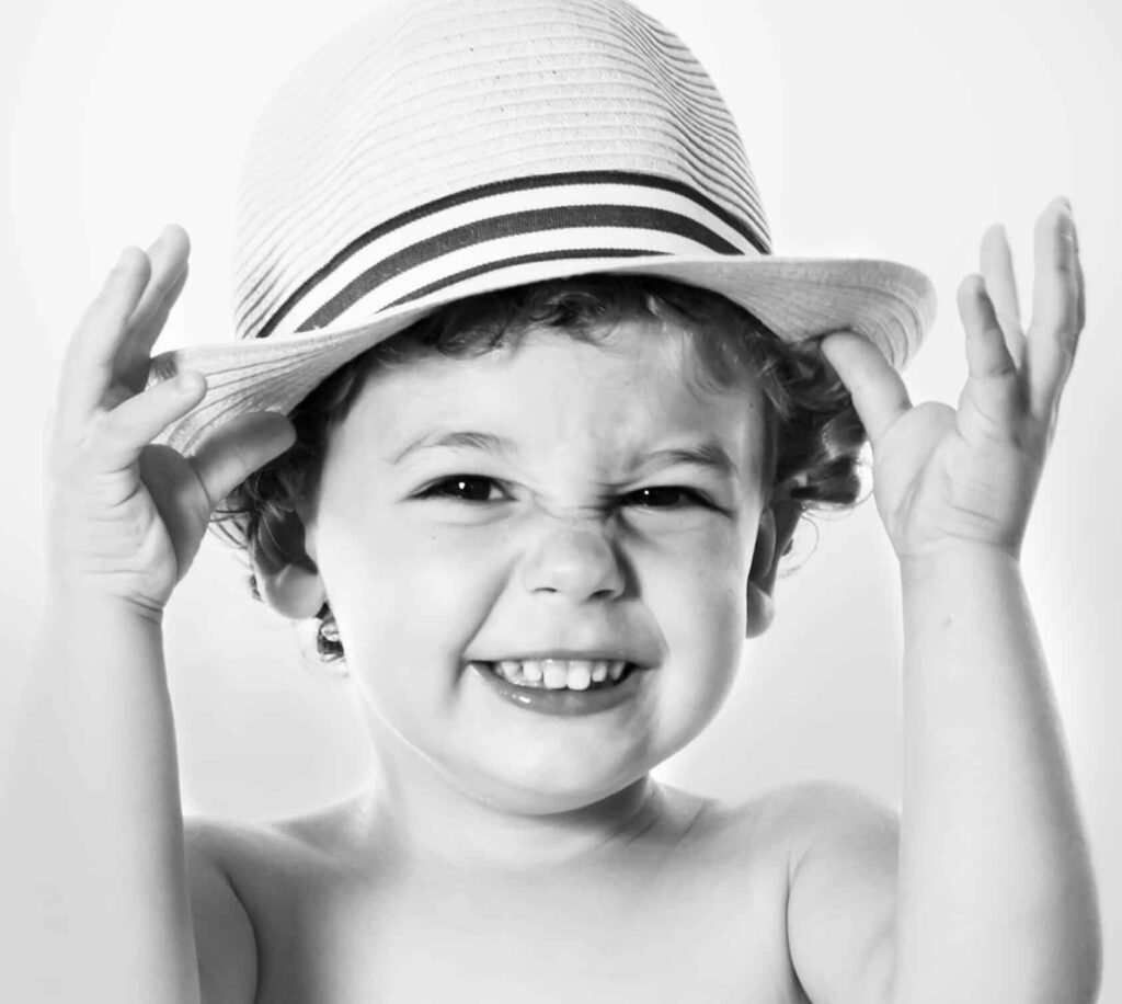 niño con gorro ríe en sesión fotos blanco y negro