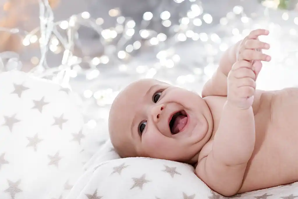 Foto de un bebé y un niño en una sesión fotográfica de Navidad, con un escenario personalizado y un estilo elegante y natural.