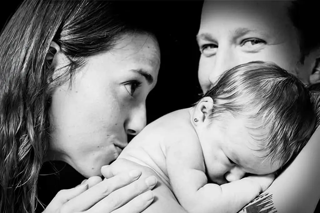 Familia con recién nacido en estudio fotográfico en blanco y negro en Sabadell